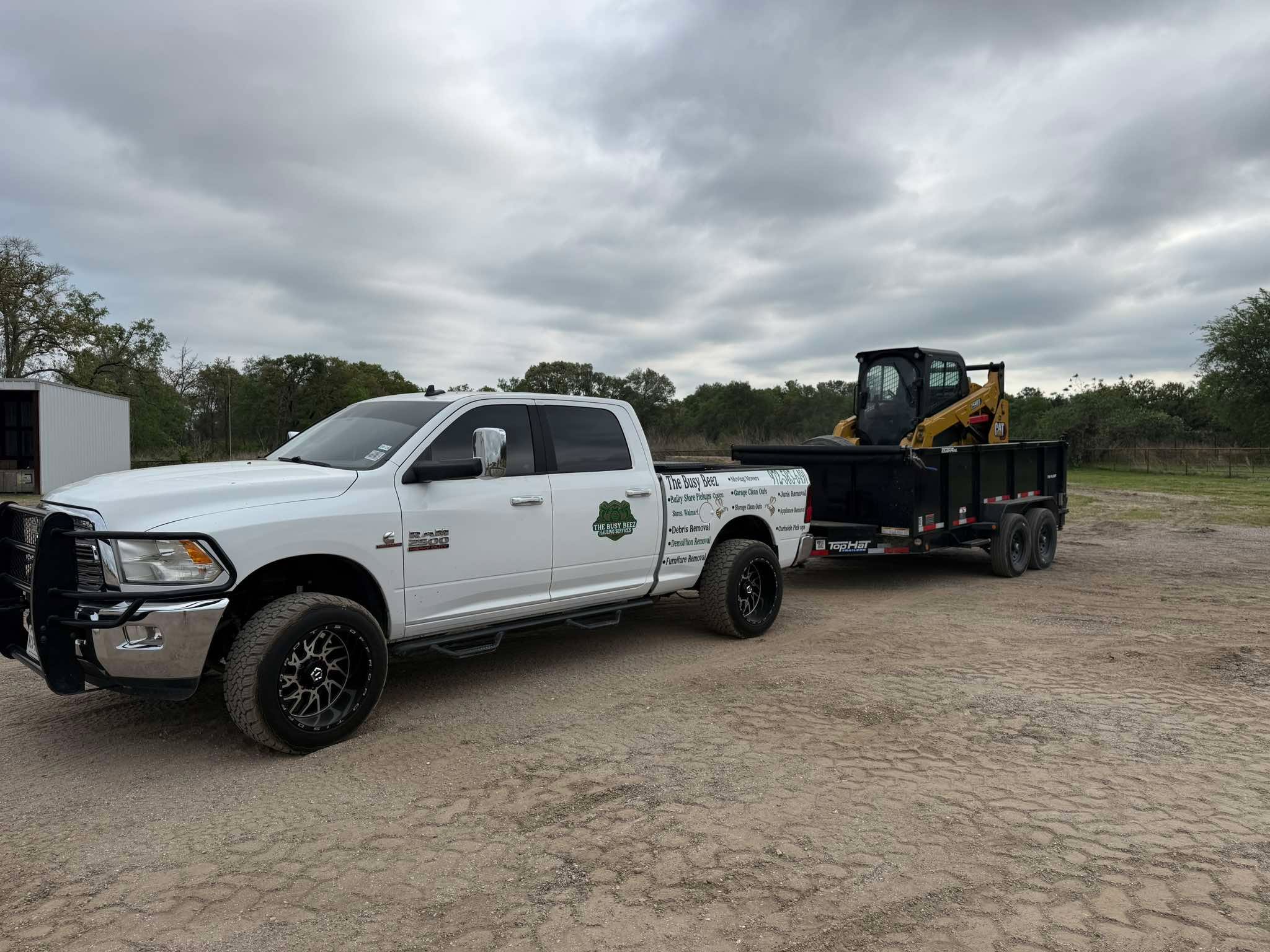 Busy Beez truck with CAT loader on dump trailer